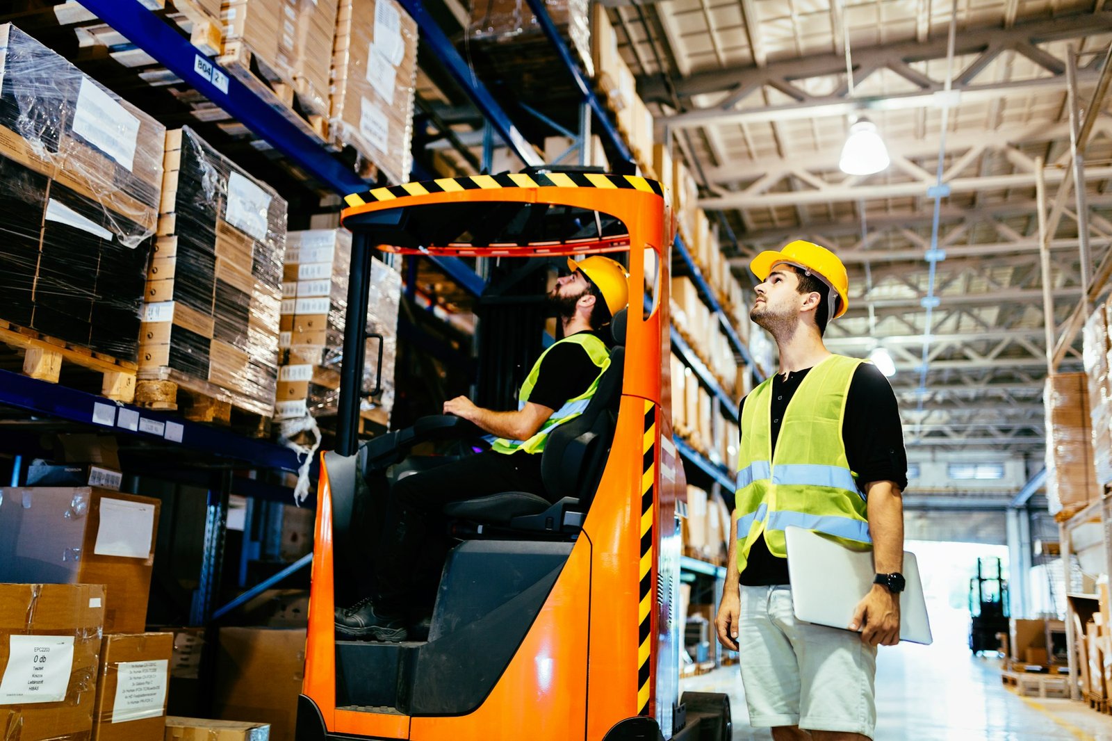 Warehouse workers working together with forklift loader